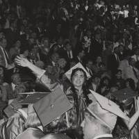 Student waving at graduation.